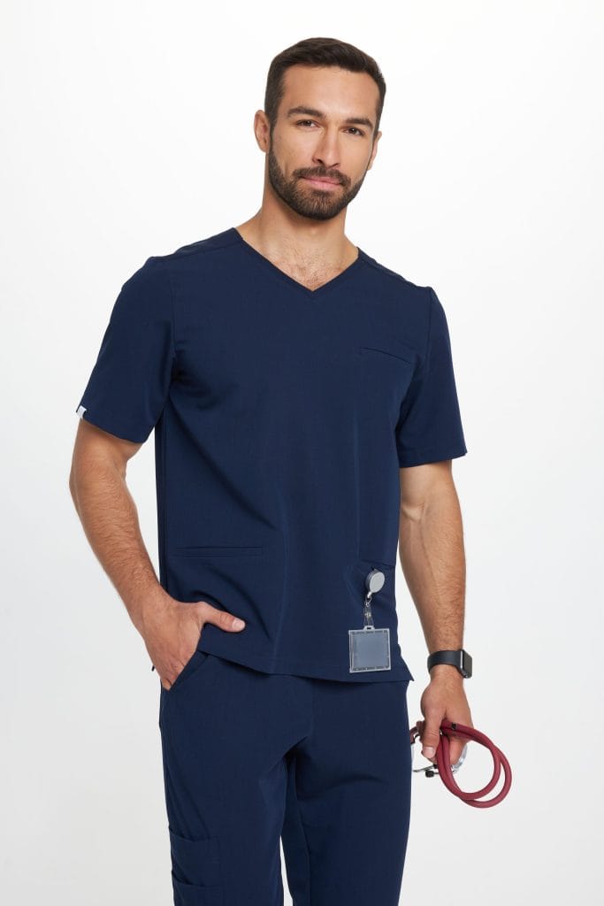 Mężczyzna w granatowym komplecie odzieży medycznej trzymający stetoskop.