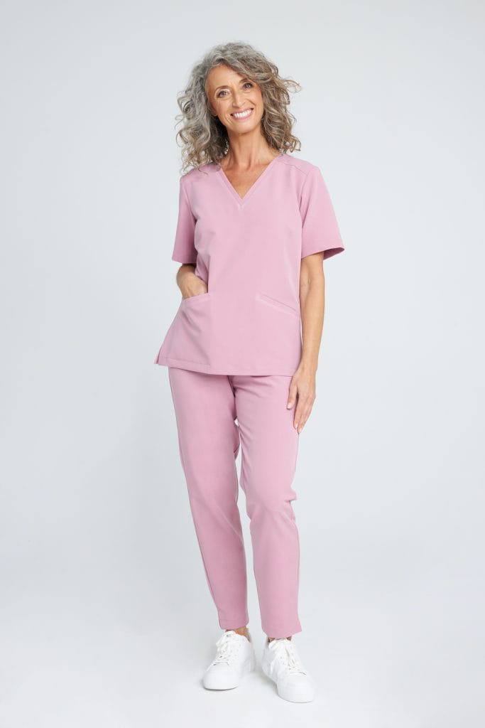 Kobieta w różowym medycznym komplecie scrubs Basic French Pink.