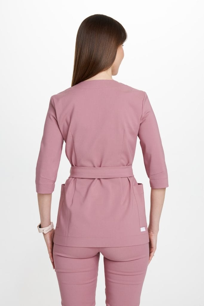 Kobieta w różowym komplecie odzieży medycznej widziana od tyłu