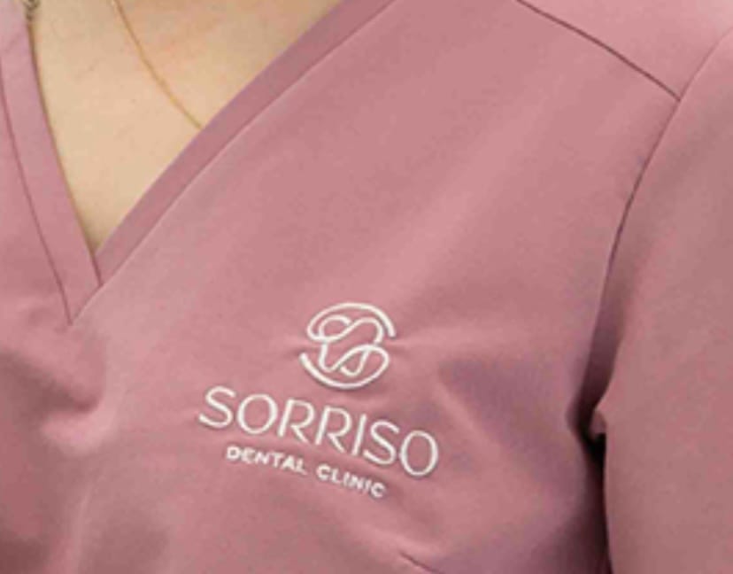 Różowa bluza medyczna z haftowanym logo kliniki dentystycznej Sorriso.