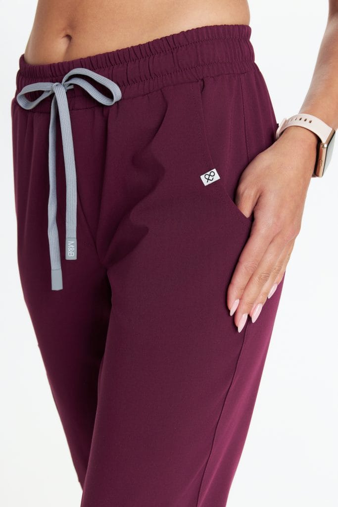 Damskie medyczne spodnie w burgundowym kolorze z elastycznym pasem i sznurkiem.