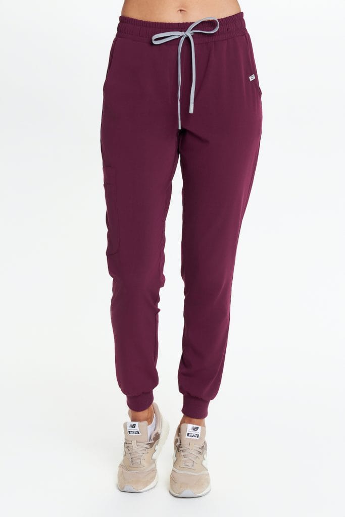 Brązowe medyczne spodnie dresowe z kieszeniami i ściągaczami przy kostkach.