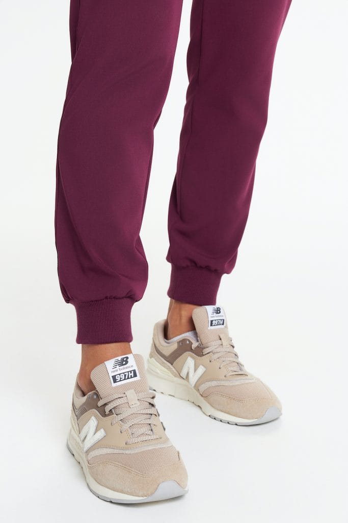 Spodnie medyczne w kolorze bordowym z elastycznymi mankietami na nogawkach.