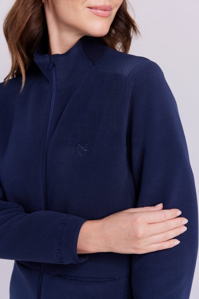 Damska granatowa bluza medyczna zapinana na zamek z subtelnym logo.