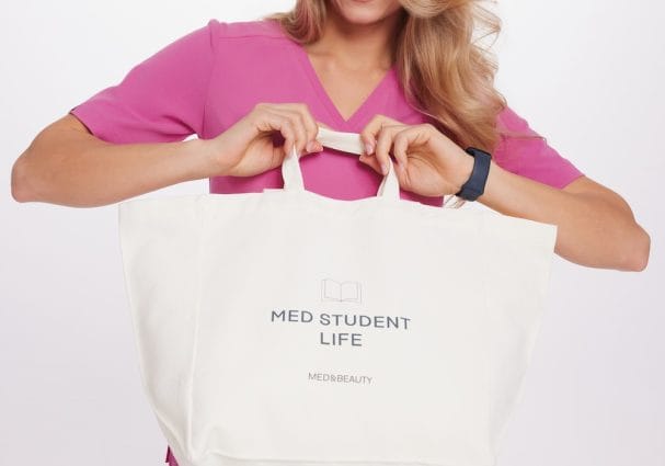 A woman in pink medical clothes holds a Med Student Life medical bag.